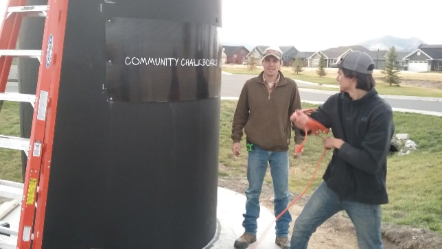 Engineering students work on community chalkboard