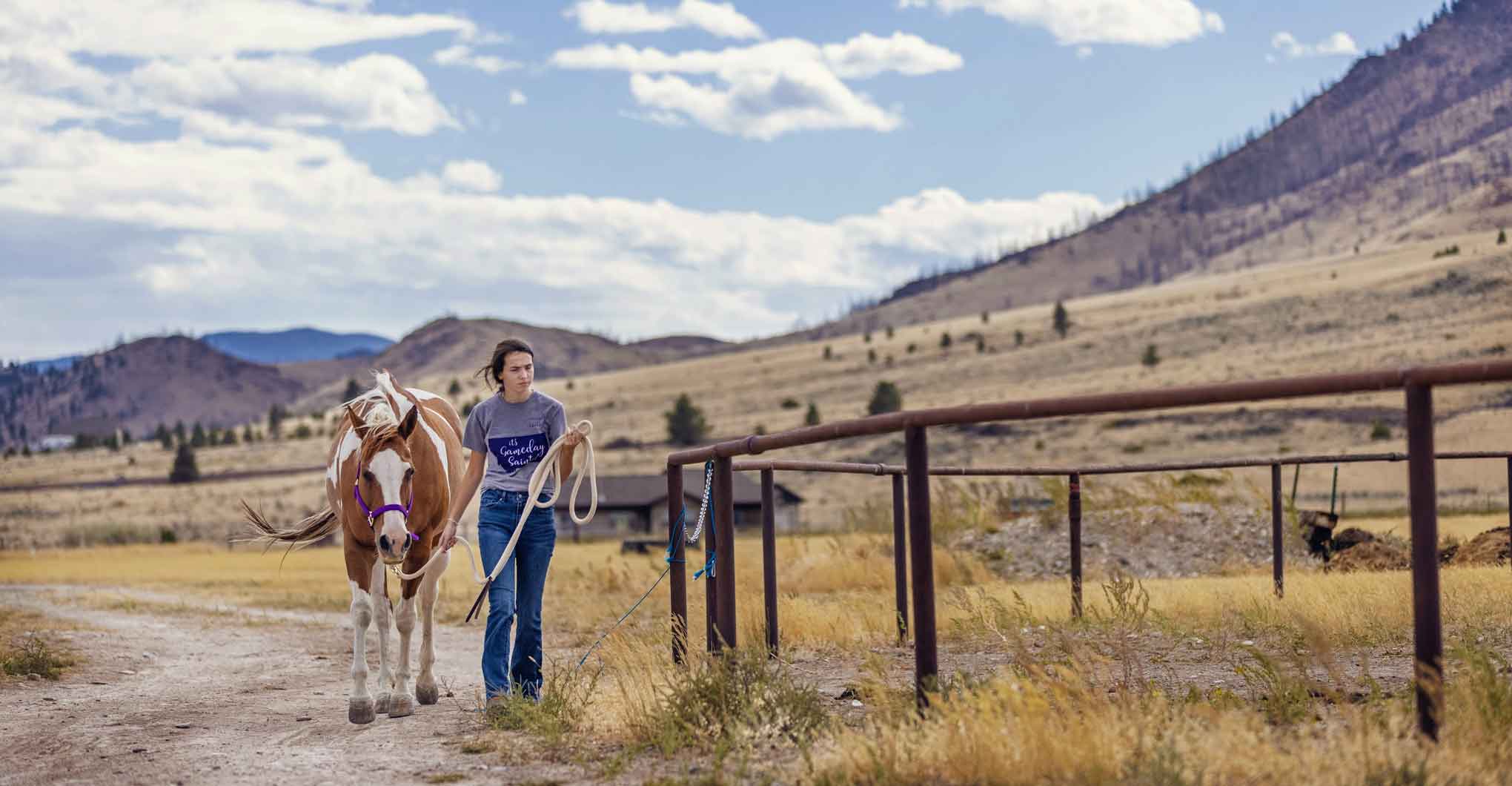 Female student and horse in Montana field and mountains