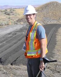 Andrew Powers working in the field wearing an orange safety vest